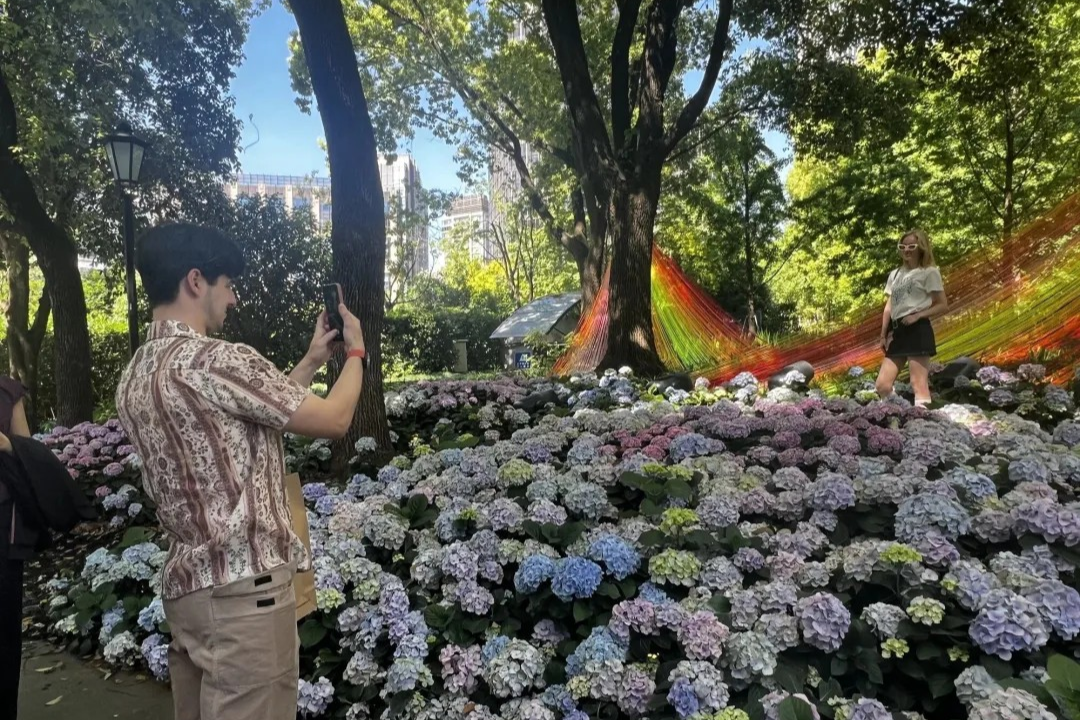 Des touristes étrangers se prennent en photo au Salon international des fleurs de Shanghai à Xintiandi