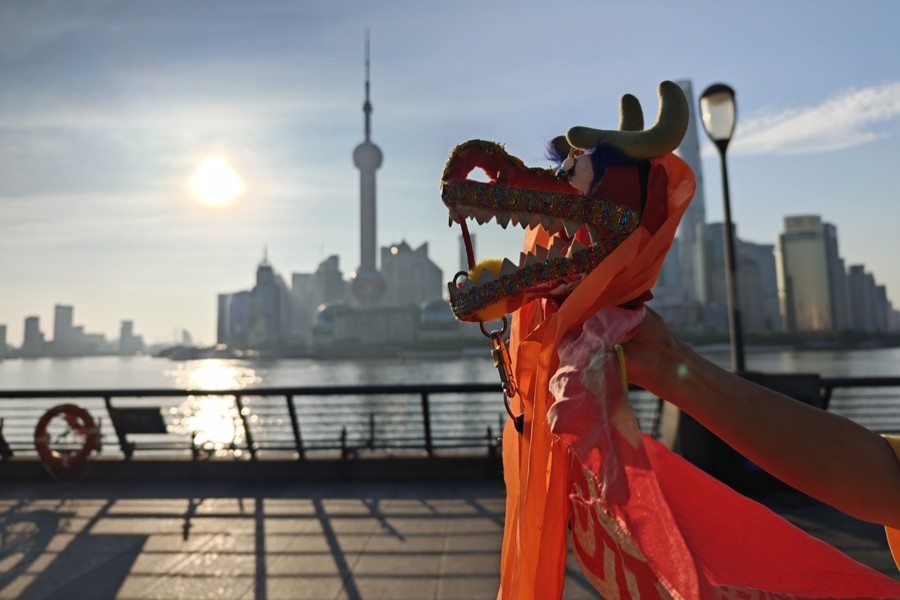 À l'aurore sur le Bund : des amis chinois et étrangers pratiquent ensemble la danse du dragon